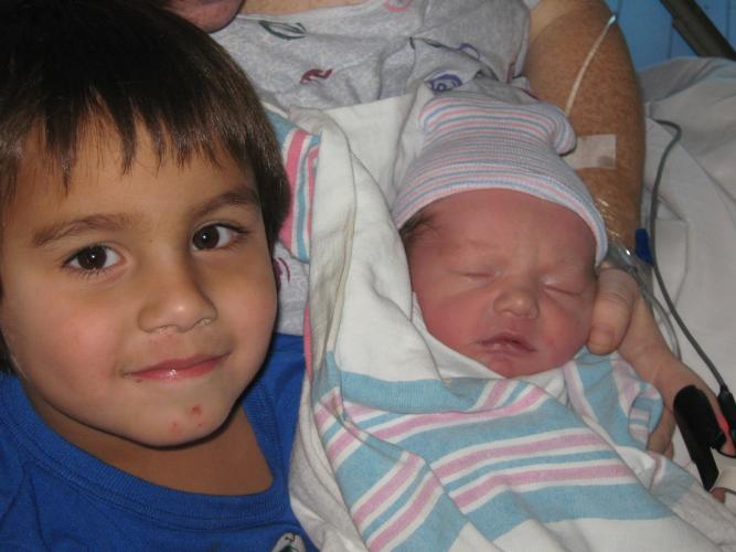 big brother holding baby for first time